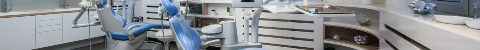 A Dental Office with Two Examination Chairs with Dentist Tools on a Table