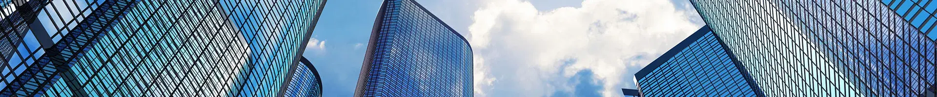 Five Large Office Buildings with the Sky and Clouds in the Background